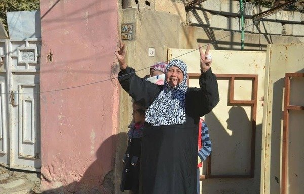 سيدة عراقية من ناحية المحاربين في الموصل ترفع علامة النصر مع دخول قوات الأمن ناحيتها بعد تحريرها من تنظيم 'الدولة الإسلامية في العراق والشام' في 24 تشرين الثاني/نوفمبر. [حقوق الصورة لقوات جهاز مكافحة الإرهاب]
