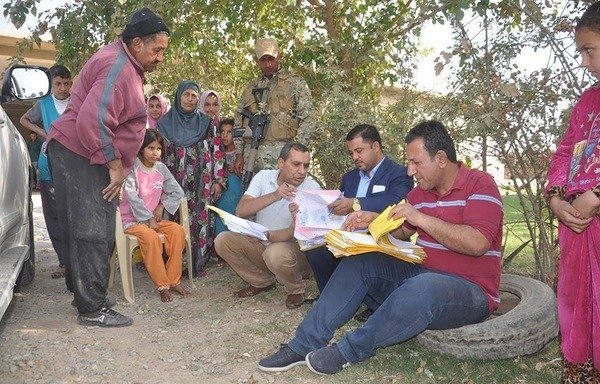 موظفون في الحكومة العراقية يجمعون المعلومات من سكان القيّارة لضمهم إلى برنامج المساعدات المالية بعد تحرير ناحيتهم في آب/أغسطس الماضي. [حقوق الصورة لوزارة العمل والشؤون الاجتماعية العراقية]