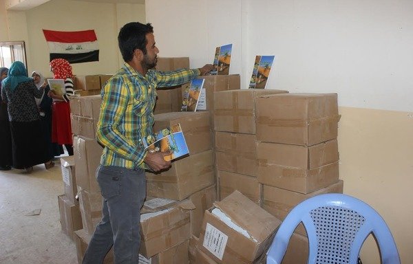 موظفون في دائرة التربية في الفلوجة يحصلون على كتب جديدة للعام الدراسي الجديد. خلال العامين المنصرمين من حكم داعش بقي الأطفال من دون تعليم. [سيف أحمد/ديارنا]