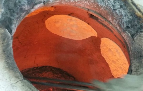 خبز التنور العراقي الشهير وهو يخبز في فرن من الطين بمخبز في شارع المصارف، أحد أكثر الشوارع ازدحاماً في الفلوجة.
