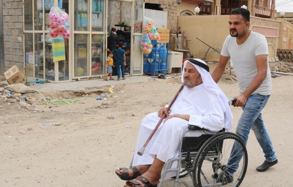 أب وابنه من حي الجولان بالفلوجة يتوجهان إلى أحد مراكز الاقتراع للإدلاء بأصواتهما. [سيف أحمد/ديارنا]