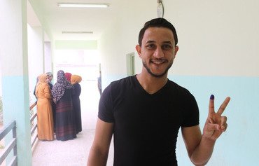 صور: أهالي الأنبار يصوتون ويحدوهم الأمل في التغيير