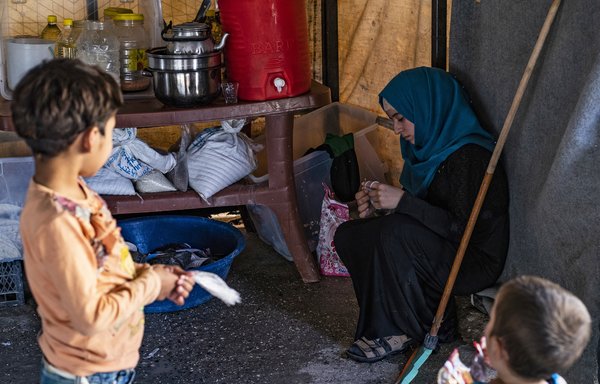 علا سلیمان الصالح داوطلبی است که از 24 کودک یتیم در اردوگاه عین عیسی مراقبت می کند، او یک پارچه را گره می زند و بچه ها به او نگاه می کنند. بنا به گزارش های رسیده این کودکان با ستیزه جوهای خارجی داعش مرتبط هستند. [دلیل سلیمان/ خبرگزاری فرانسه]