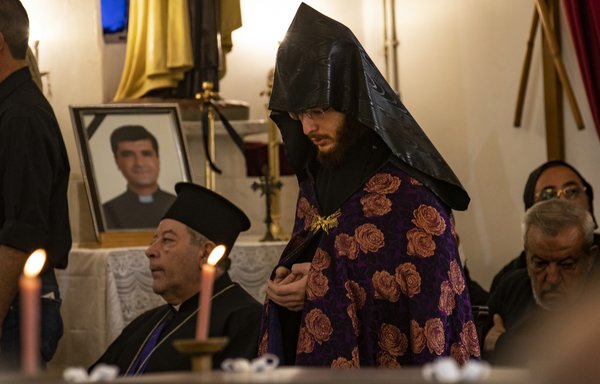 كاهن يؤدي الصلاة خلال جنازة الأب جوزيف حنا إبراهيم ووالده في كنيسة مار يوسف في القامشلي يوم 12 تشرين الثاني/نوفمبر. (دليل سليمان / وكالة الصحافة الفرنسية