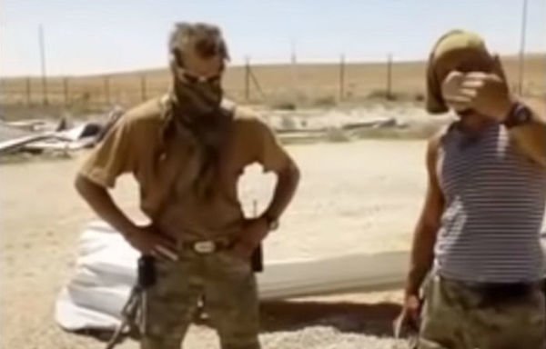 لقطة من شريط مصور متداول على شبكة الإنترنت يظهر فيها عنصران من مجموعة فاغنر وهما يعذبان رجلًا سوريًا قبل قتله والتمثيل بجثته عام 2017.