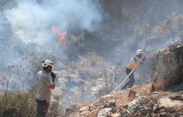 الخوذ البيضاء تطفئ الحرائق في محافظة إدلب